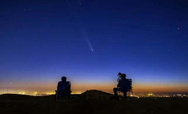 Comet Tsuchinshan-Atlas makes an appearance in the western night sky as amateur photographers Nolan Letellier, left, and Link Jackson observe on a ridge near the Dry Creek Trailhead in Boise, Idaho. Monday, Oct. 14, 2024 (AP Photo/Kyle Green)