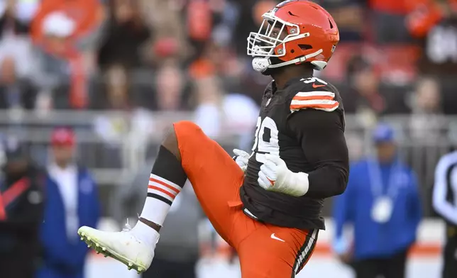 Cleveland Browns defensive end Za'Darius Smith (99) celebrates a sack of Baltimore Ravens quarterback Lamar Jackson (8) during the second half of an NFL football game in Cleveland, Sunday, Oct. 27, 2024. (AP Photo/David Richard)