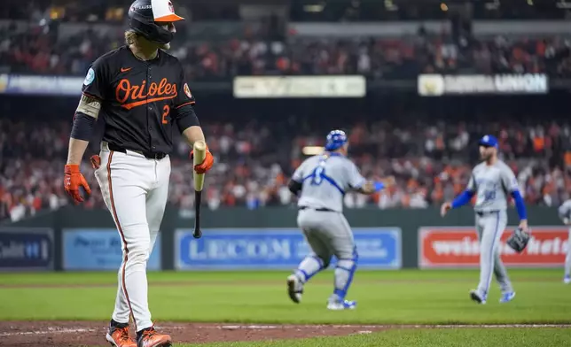 Baltimore Orioles' Gunnar Henderson, left, walks to the dugout after striking out for the final out as Kansas City Royals pitcher Lucas Erceg, right, and catcher Salvador Perez react following Game 2 of an AL Wild Card Series baseball game, Wednesday, Oct. 2, 2024 in Baltimore. The Royals won 2-1. (AP Photo/Stephanie Scarbrough)