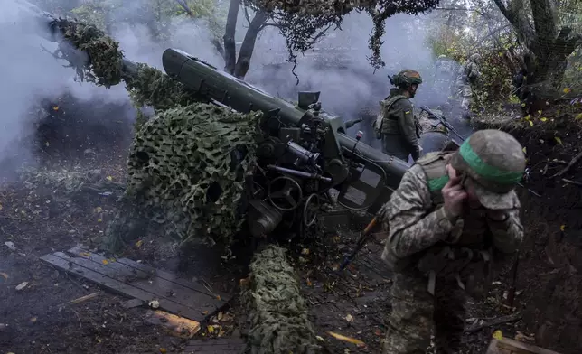 Ukrainian servicemen of Khartia brigade fire D-30 Howitzer towards Russian positions in Kharkiv region, Ukraine, Wednesday, Oct. 16, 2024. (AP Photo/Alex Babenko)