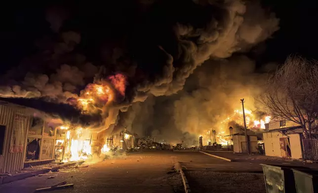 A local market burns after a Russian strike in Mykolaiv, Ukraine Tuesday, Oct. 15, 2024. (AP Photo/Marko Ivkov)