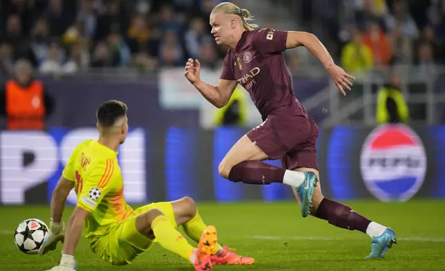 Manchester City's Erling Haaland takes the ball past Slovan's goalkeeper Dominik Takac to score his side's throw goal during the Champions League opening phase soccer match between Slovan Bratislava and Manchester City in Bratislava, Slovakia, Tuesday, Oct. 1, 2024. (AP Photo/Petr Josek)