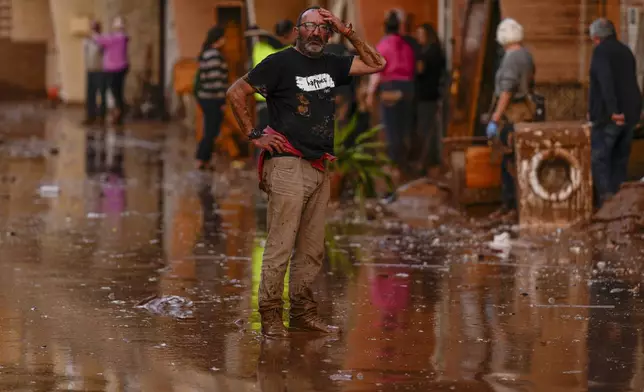 A man reacts in front of houses affected by floods in Utiel, Spain, Wednesday, Oct. 30, 2024. (AP Photo/Manu Fernandez)