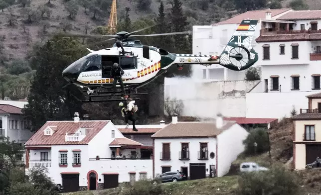 Emergency teams rescue a person who was stranded by the water in a Guardia Civil helicopter, after the floods preceded by heavy rains that caused the overflow of the river in the town of Alora, Malaga, Spain, Tuesday, Oct. 29, 2024. (AP Photo/Gregorio Marrero)