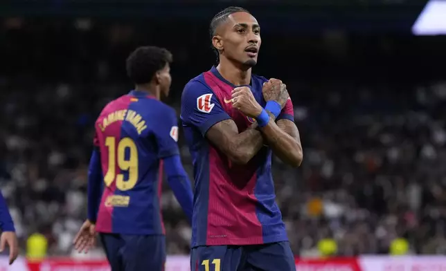 Barcelona's Raphinha celebrates after scoring his side's fourth goal during a Spanish La Liga soccer match between Real Madrid and Barcelona at the Santiago Bernabeu stadium in Madrid, Spain, Saturday, Oct. 26, 2024. (AP Photo/Manu Fernandez)