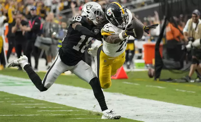 Pittsburgh Steelers running back Najee Harris, right, dives for the end zone to score past Las Vegas Raiders cornerback Jack Jones during the second half of an NFL football game in Las Vegas, Sunday, Oct. 13, 2024. (AP Photo/John Locher)