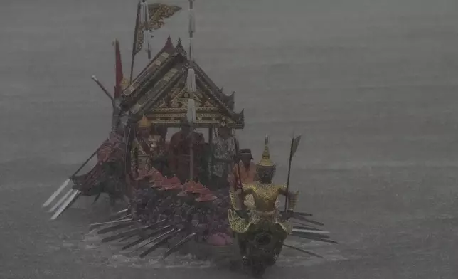 Oarsmen paddle his boat in heavy rain during a dress rehearsal for the Royal barge ceremony on the Chao Phraya River in Bangkok in Bangkok, Thailand, Tuesday, Oct. 22, 2024. The procession to make merit at a Thai Buddhist temple is scheduled for Oct. 27, 2024, after the Buddhist Lent has concluded. (AP Photo/Sakchai Lalit)