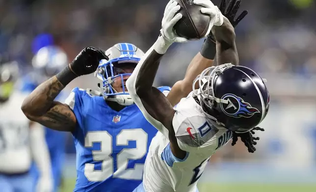 Tennessee Titans wide receiver Calvin Ridley (0) makes a catch past Detroit Lions safety Brian Branch (32) during the first half of an NFL football game Sunday, Oct. 27, 2024, in Detroit. (AP Photo/Carlos Osorio)