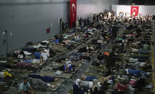 Hundreds of people, mostly Turkish citizens, rest on board a Turkish military ship evacuating them from Lebanon to Turkey, in Beirut port, on Thursday, Oct. 10, 2024. (AP Photo/Emrah Gurel)