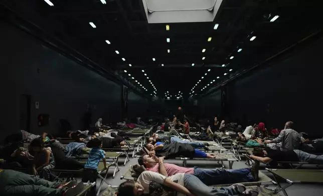 People, mostly Turkish citizens, rest on board of a Turkish military ship evacuating them from Lebanon to Turkey, in Beirut port, on Thursday, Oct. 10, 2024. (AP Photo/Emrah Gurel)