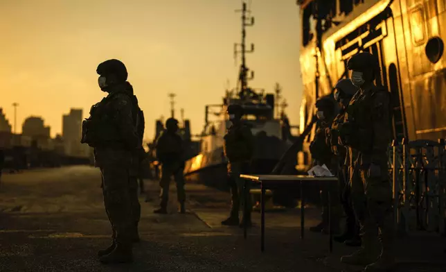 Turkish security officials stand guard next to Turkish military ships preparing to evacuate citizens from Lebanon to Turkey in Beirut port, Wednesday, Oct. 9, 2024. (AP Photo/Emrah Gurel)