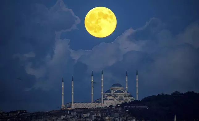 A supermoon rises behind the Camlica mosque in Istanbul, Turkey, Thursday, Oct. 17, 2024. (AP Photo/Emrah Gurel)