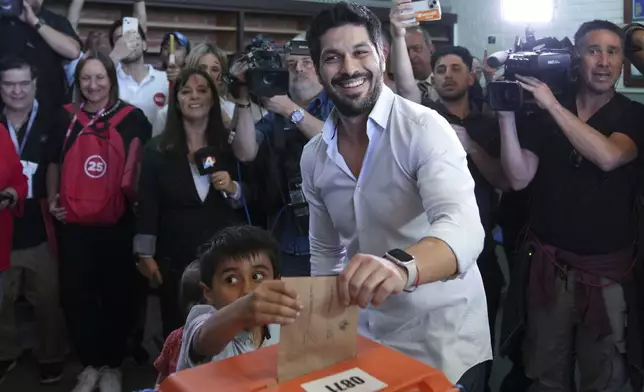 Andres Ojeda, Colorado Party presidential candidate, votes alongside his nephew at a polling station during general elections in Montevideo, Uruguay, Sunday, Oct. 27, 2024. (AP Photo/Matilde Campodonico)