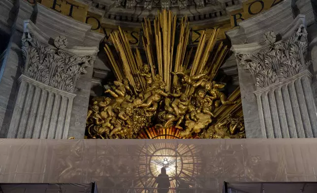 Journalists look, Tuesday, Oct. 8, 2024, at the restoration works of the Cathedra of St. Peter's inside St. Peter's Basilica at The Vatican. Bernini's monumental bronze canopy has been under restoration too since February while expert conservators worked meticulously on its intricate surface. (AP Photo/Domenico Stinellis)