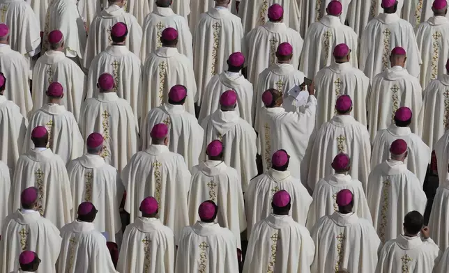 A bishop uses a smartphone as Pope Francis presides over a mass in St. Peter's Square, at the Vatican, for the opening of the second session of the 16th General Assembly of the Synod of Bishops, Wednesday, Oct. 2, 2024. (AP Photo/Gregorio Borgia)