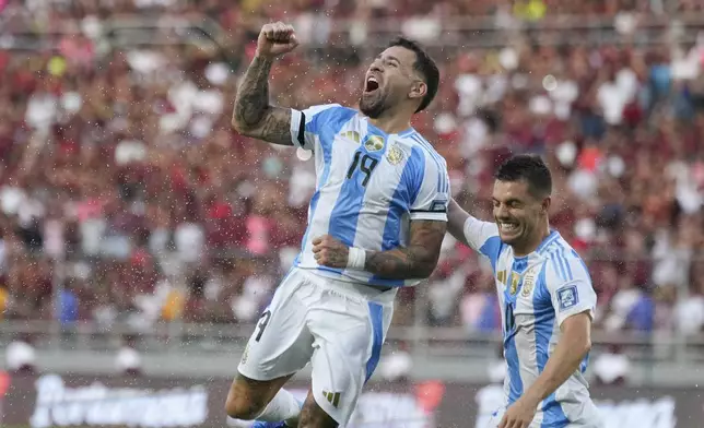 Argentina's Nicolas Otamendi (19) celebrates with Giovani Lo Celso after scoring his side's opening goal against Venezuela during a FIFA World Cup 2026 qualifying soccer match in Maturin, Venezuela, Thursday, Oct. 10, 2024. (AP Photo/Ariana Cubillos)