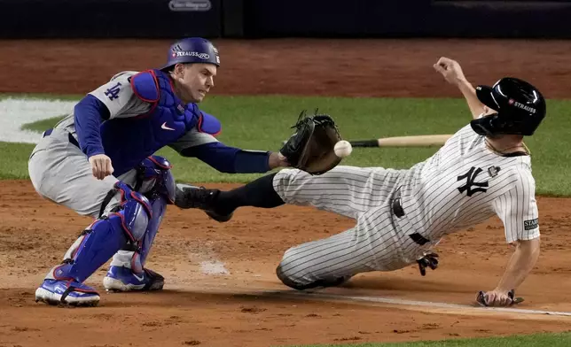 New York Yankees' Giancarlo Stanton is tagged out at home by Los Angeles Dodgers catcher Will Smith during the fourth inning in Game 3 of the baseball World Series, Monday, Oct. 28, 2024, in New York. (AP Photo/Frank Franklin II)