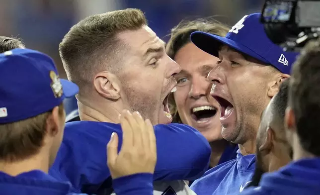 Los Angeles Dodgers' Freddie Freeman, left, celebrates with starting pitcher Jack Flaherty, right, and teammates after hitting a walk-off grand slam against the New York Yankees during the 10th inning in Game 1 of the baseball World Series, Friday, Oct. 25, 2024, in Los Angeles. The Dodgers won 6-3. (AP Photo/Godofredo A. Vásquez)