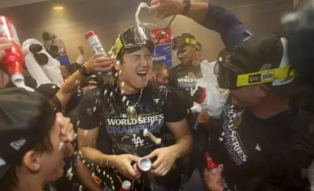 Los Angeles Dodgers' Shohei Ohtani celebrates in the locker room after their win against the New York Yankees in Game 5 to win the baseball World Series, Thursday, Oct. 31, 2024, in New York. (AP Photo/Ashley Landis)