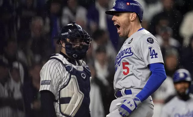 Los Angeles Dodgers' Freddie Freeman (5) celebrates after hitting a two-run home run as New York Yankees catcher Austin Wells watches during the first inning in Game 4 of the baseball World Series, Tuesday, Oct. 29, 2024, in New York. (AP Photo/Godofredo A. Vásquez)