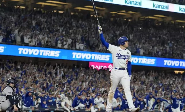 Los Angeles Dodgers' Freddie Freeman celebrates his walk-off grand slam home run against the New York Yankees during the 10th inning in Game 1 of the baseball World Series, Friday, Oct. 25, 2024, in Los Angeles. (AP Photo/Ashley Landis)