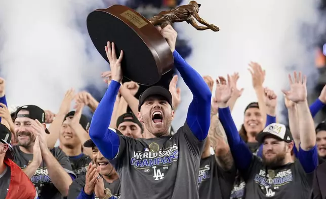 Los Angeles Dodgers' Freddie Freeman celebrates with the MVP trophy after their win against the New York Yankees in Game 5 to win the baseball World Series, Thursday, Oct. 31, 2024, in New York. (AP Photo/Ashley Landis)