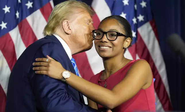 Republican presidential nominee former President Donald Trump kisses Michaella Lawrence at a campaign event at Discovery World, Friday, Oct. 1, 2024, in Milwaukee. (AP Photo/Alex Brandon)