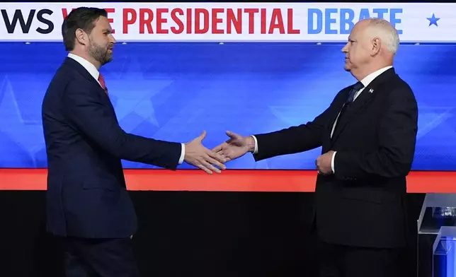 Republican vice presidential nominee Sen. JD Vance, R-Ohio, left, and Democratic vice presidential nominee Minnesota Gov. Tim Walz, shake hands as they arrive for a CBS News vice presidential debate, Tuesday, Oct. 1, 2024, in New York. (AP Photo/Julia Demaree Nikhinson)