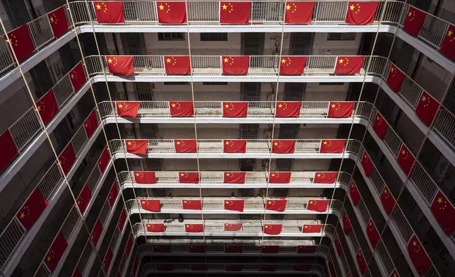 Flags of China are hung in a residential building to mark the 75th National Day of the People's Republic of China in Hong Kong, Tuesday, Oct. 1, 2024. (AP Photo/Chan Long Hei)