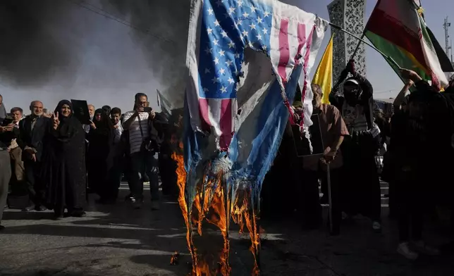 Demonstrators burn representations of the U.S. and Israeli flags in a rally commemorating slain Hezbollah leader Hassan Nasrallah, in Tehran, Iran, Wednesday, Oct. 2, 2024. (AP Photo/Vahid Salemi)