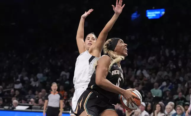 New York Liberty's Kayla Thornton (5) drives past Las Vegas Aces' Kelsey Plum (10) during the first half of a WNBA basketball semifinal game, Tuesday, Oct. 1, 2024, in New York. (AP Photo/Frank Franklin II)