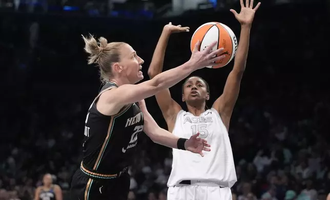 New York Liberty's Courtney Vandersloot (22) shoots over Las Vegas Aces' Tiffany Hayes (15) during the first half of a WNBA basketball semifinal game, Tuesday, Oct. 1, 2024, in New York. (AP Photo/Frank Franklin II)