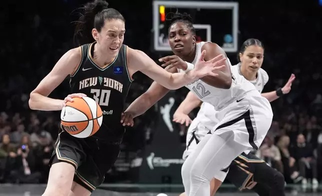 New York Liberty's Breanna Stewart (30) drives past Las Vegas Aces' Chelsea Gray (12) during the first half of a WNBA basketball semifinal game, Tuesday, Oct. 1, 2024, in New York. (AP Photo/Frank Franklin II)