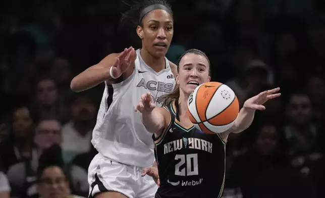 New York Liberty's Sabrina Ionescu (20) passes away from Las Vegas Aces' A'ja Wilson (22) during the second half of a WNBA basketball semifinal game, Tuesday, Oct. 1, 2024, in New York. The Liberty won 88-84. (AP Photo/Frank Franklin II)