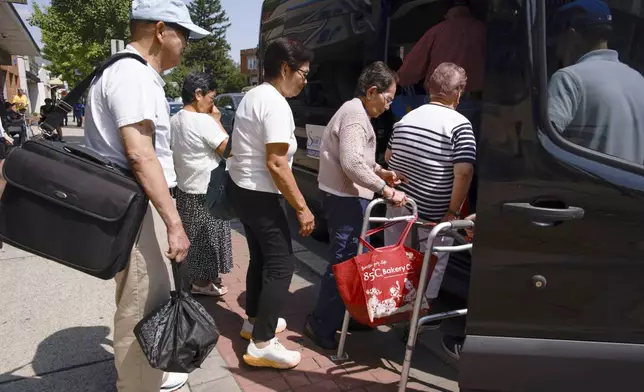 People line up to get into a van to go home outside of Sunshine Adult Day Center in Bergenfield, N.J., Monday, Aug. 26, 2024. (AP Photo/Kena Betancur)