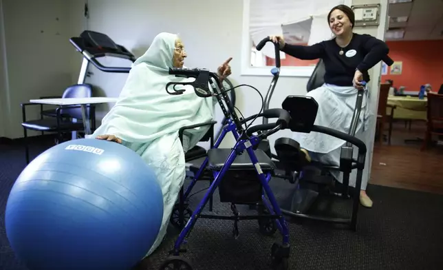 Bibi, 84, talks to Hadassah Wilhelm, director of community relations, during a physical therapy session at Sunshine Adult Day Center in Bergenfield, N.J., Monday, Aug. 26, 2024. (AP Photo/Kena Betancur)