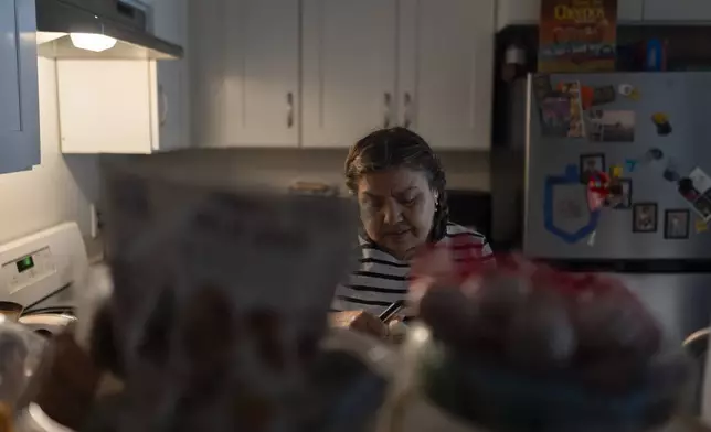 Marina Maalouf, a longtime resident of Hillside Villa who participated in protests after rents doubled in 2019, peels potatoes in her apartment in Los Angeles, Tuesday, Oct. 1, 2024. (AP Photo/Jae C. Hong)