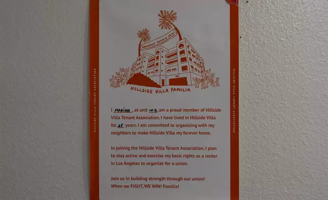 A poster symbolizing solidarity within the tenant community hangs on the wall of Marina Maalouf's apartment in Los Angeles, Tuesday, Oct. 1, 2024. Maalouf, a longtime Hillside Villa apartment complex resident, participated in protests after rents doubled in 2019. (AP Photo/Jae C. Hong)