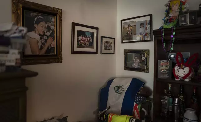 A wall in Marina Maalouf's apartment is adorned with family photos as an El Salvadoran flag is draped over an American flag in Los Angeles, Tuesday, Oct. 1, 2024. (AP Photo/Jae C. Hong)