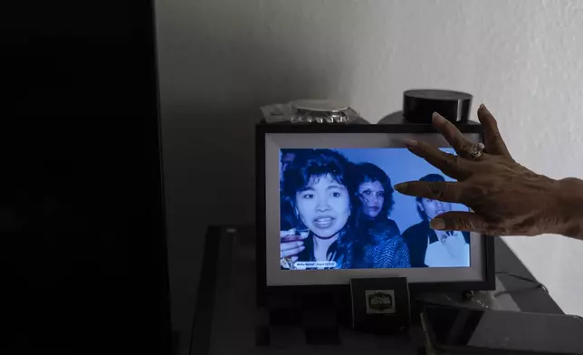 Marina Maalouf, a longtime resident of Hillside Villa who participated in protests after rents doubled in 2019, scrolls through a digital album in her apartment in Los Angeles, Tuesday, Oct. 1, 2024. (AP Photo/Jae C. Hong)