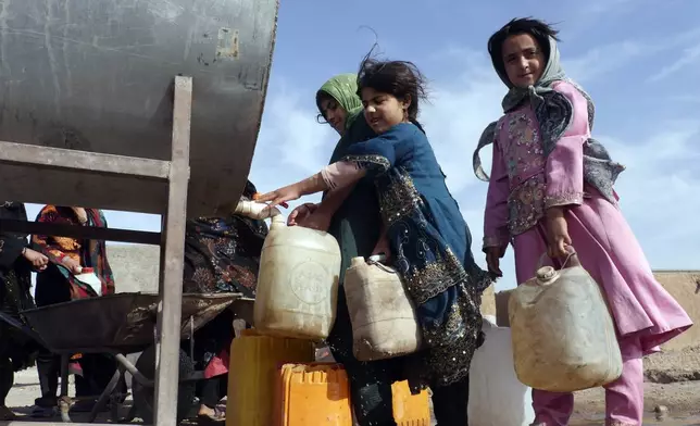 Survivors gather around a water tanker to get potable waterin Zinda Jan district, of Herat province, in western Afghanistan, Saturday, Sept. 28, 2024 following a 6.3 magnitude earthquake on Oct. 7, 2023. (AP Photo/Omid Haqjoo)