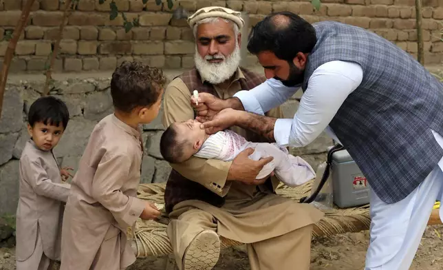 A health worker administers a polio vaccine to a child at a neighborhood of Jalalabad, east of Kabul, Afghanistan, Tuesday, Oct. 29, 2024. (AP Photo/Shafiullah Kakar)