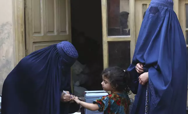 A health worker, left, marks a finger of a child after giving a polio vaccine at a neighborhood of Jalalabad, east of Kabul, Afghanistan, Tuesday, Oct. 29, 2024. (AP Photo/Shafiullah Kakar)