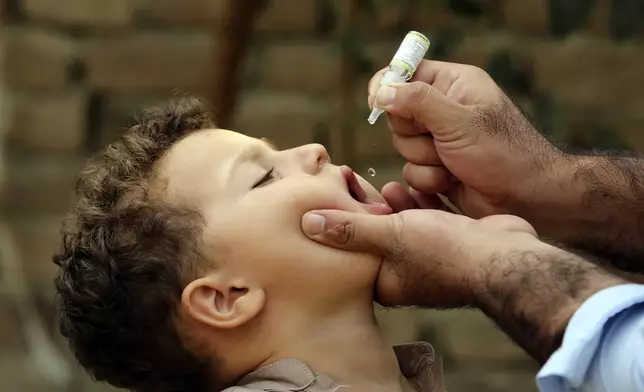 A health worker administers a polio vaccine to a child at a neighborhood of Jalalabad, east of Kabul, Afghanistan, Tuesday, Oct. 29, 2024. (AP Photo/Shafiullah Kakar)