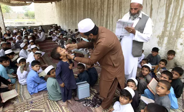 A health worker administers a polio vaccine to a boy at a local Madrassa, at a neighborhood of Jalalabad, east of Kabul, Afghanistan, Tuesday, Oct. 29, 2024. (AP Photo/Shafiullah Kakar)