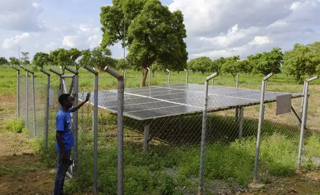 A young man stands by a community radio station solar setup sponsored by a German NGO in Gushegu northern, Ghana, Friday Sept. 6, 2024. (AP Photos/Abdul Haqq Mahama)