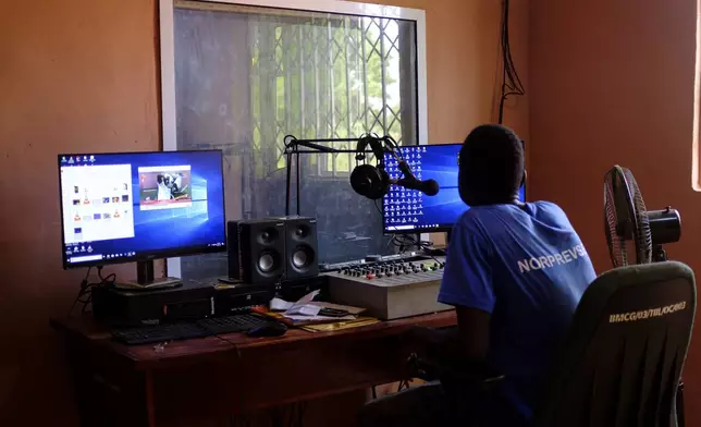 A man sits in a community radio station powered by a solar setup sponsored by a German NGO in Gushegu northern, Ghana, Friday Sept. 6, 2024. (AP Photos/Abdul Haqq Mahama)