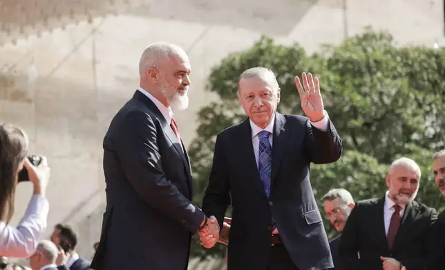 Turkey's President Recep Tayyip Erdogan waves as Prime Minister of Albania Edi Rama, welcomes him before their meeting in Tirana, Albania, Thursday, Oct. 10, 2024. (AP Photo/Hameraldi Agolli)