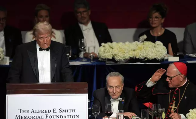 Republican presidential nominee former President Donald Trump speaks at the 79th annual Alfred E. Smith Memorial Foundation Dinner, Thursday, Oct. 17, 2024, in New York, as Senate Majority Leader Chuck Schumer of N.Y., and Cardinal Timothy Dolan listen. (AP Photo/Julia Demaree Nikhinson)