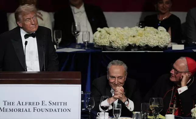 Republican presidential nominee former President Donald Trump speaks at the 79th annual Alfred E. Smith Memorial Foundation Dinner, Thursday, Oct. 17, 2024, in New York, as Senate Majority Leader Chuck Schumer of N.Y., and Cardinal Timothy Dolan listen. (AP Photo/Julia Demaree Nikhinson)